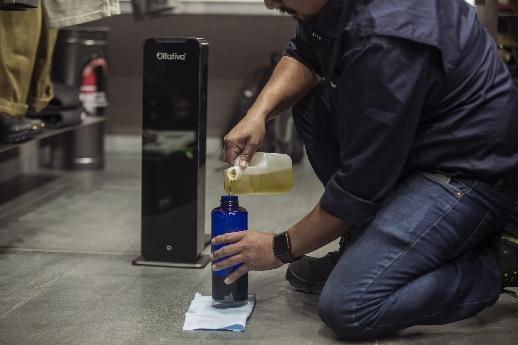 Técnico de Olfativa cargando el difusor de aroma con protocolo de vaciado en tienda