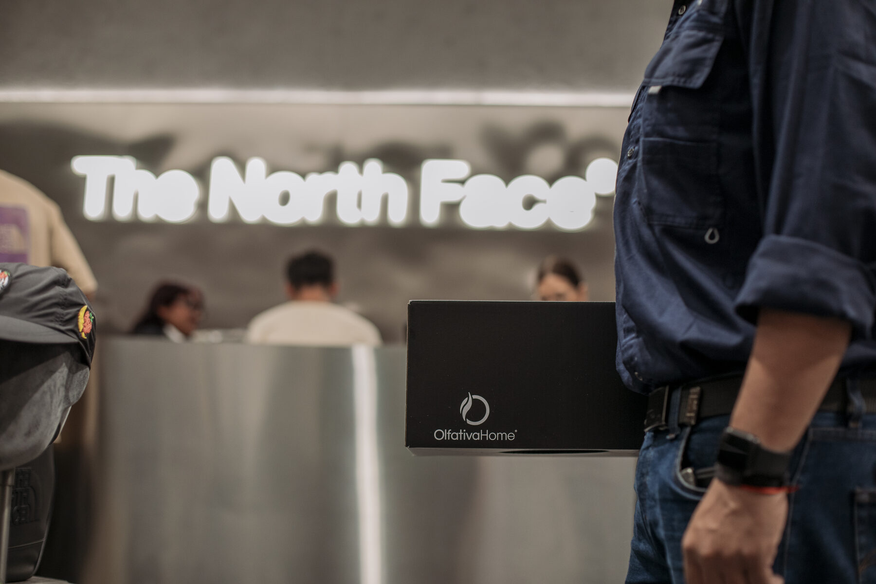 Técnico de Olfativa entrando a la tienda The North Face con el equipo de difusión de aroma